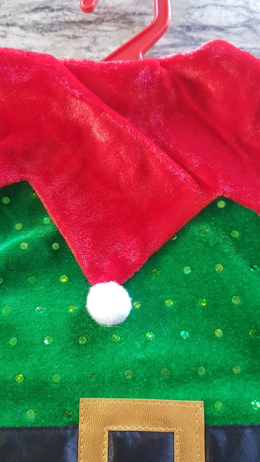 Red and green Christmas-themed fabric with a white pom-pom and wooden frame.
