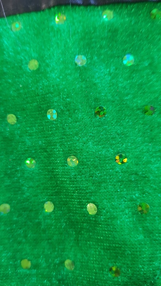 Close-up of green fabric with embedded stones.