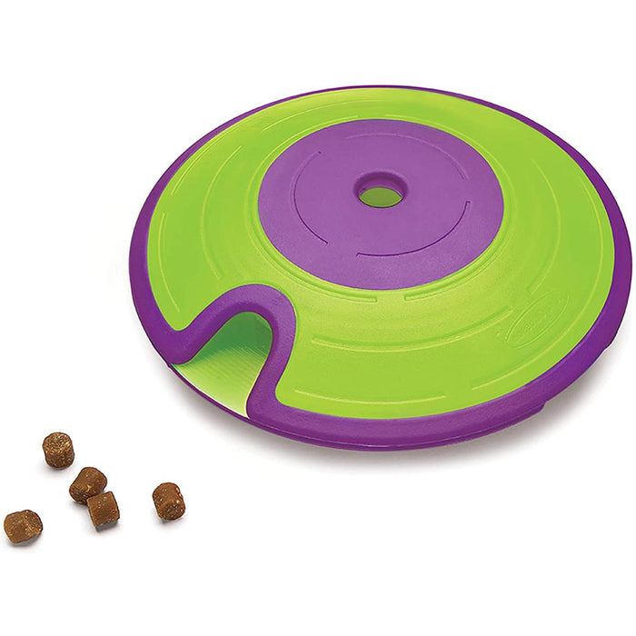 A green and purple Nina Ottosson by Outward Hound interactive dog toy, which is a maze puzzle designed to dispense treats.